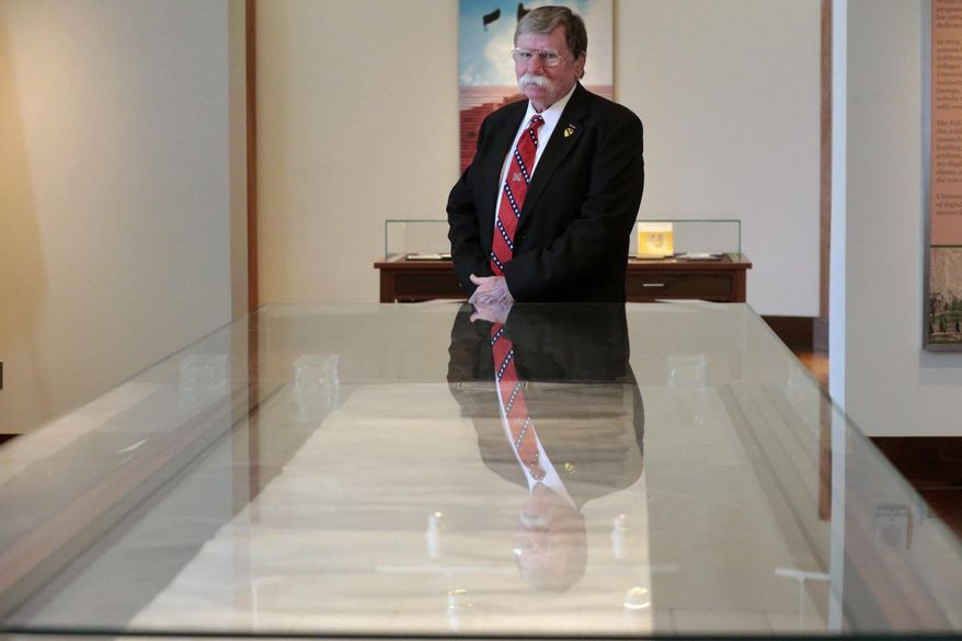 FILE - In this Friday, March 10, 2017 file photo, John Maxey poses for a portrait in front of the Constitution of the Confederate States of America in Athens, Ga. With the nation locked in debates over Confederate symbols, the very document that laid out the legal framework of a government built to preserve slavery will spend its 160th anniversary where it spends nearly every other day: Tucked away in a university archive. (John Roark/Athens Banner-Herald via AP, File)