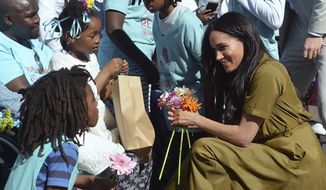 In this Sept. 24, 2019, file photo, Meghan, the Duchess of Sussex, talks to children during a walkabout in Bo-Kaap, a heritage site, in Cape Town, South Africa. In countries with historic ties to Great Britain, allegations by Prince Harry and Meghan about racism within the royal family have raised questions about whether those nations want to be closely connected to Britain anymore after the couple&#39;s interview with Oprah Winfrey. (Courtney Africa/Pool via AP, File)