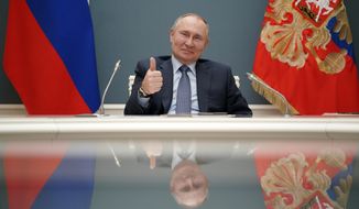 Russian President Vladimir Putin shows a thumbs-up as he takes part in a ceremony with his Turkish counterpart Recep Tayyip Erdogan via video conference of remotely inaugurating the construction of a third nuclear reactor of Akkuyu power plant in southern Turkey, in Moscow, Russia, Wednesday, March 10, 2021. The presidents of Turkey and Russia have remotely inaugurated the construction of a third nuclear reactor of Akkuyu power plant in southern Turkey, vowing to continue their close cooperation. (Alexei Druzhinin, Sputnik, Kremlin Pool Photo via AP)