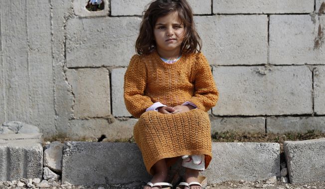 A displaced Syrian girl sits outside her family&#x27;s tent at a refugee camp in Bar Elias, Bekaa Valley, Lebanon, Friday, March 5, 2021. UNICEF said Wednesday, March 10, 2021 that Syria’s 10-year-long civil war has killed or wounded about 12,000 children and left millions out of school in what could have repercussions for years to come in the country. The country&#x27;s bitter conflict has killed nearly half a million people, wounded more than a million and displaced half the country’s population, including more than 5 million as refugees. (AP Photo/Hussein Malla)