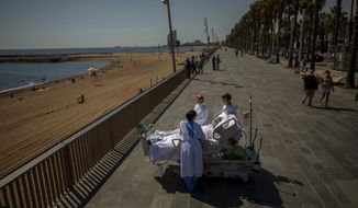 FILE - In this Sept. 4, 2020, file photo, Francisco Espana, 60, is surrounded by members of his medical team as he looks at the Mediterranean sea from a promenade next to the &amp;quot;Hospital del Mar&amp;quot; in Barcelona, Spain. Francisco spent 52 days in the Intensive Care unit at the hospital due to coronavirus, but today he was allowed by his doctors to spend almost ten minutes at the seaside as part of his recovery therapy. (AP Photo/Emilio Morenatti, File)