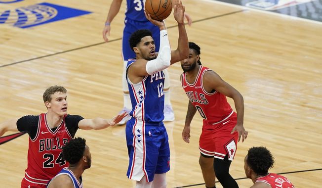 Philadelphia 76ers forward Tobias Harris (12) goes up for a shot as Chicago Bulls forward Lauri Markkanen, left, guard Coby White and center Wendell Carter Jr., right, watch during the second half of an NBA basketball game in Chicago, Thursday, March 11, 2021. (AP Photo/Nam Y. Huh)