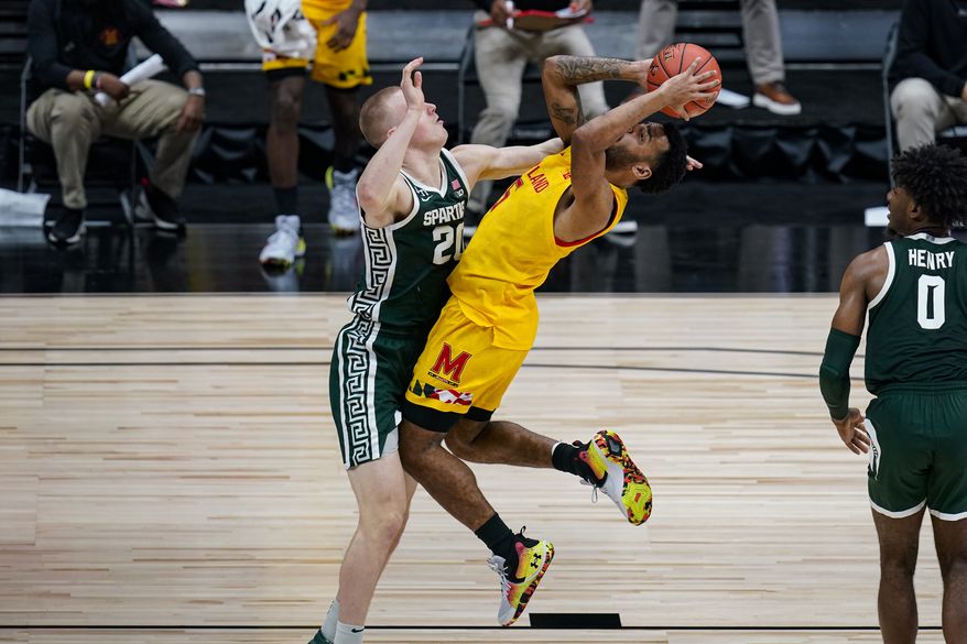 Maryland guard Eric Ayala (5) hits a shot over Michigan State forward Joey Hauser (20) in the second half of an NCAA college basketball game at the Big Ten Conference tournament in Indianapolis, Thursday, March 11, 2021. (AP Photo/Michael Conroy)