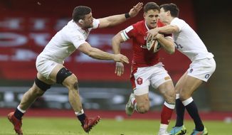 Wales&#39; Kieran Hardy, centre, is tackled by England&#39;s Mark Wilson, left and England&#39;s Ben Youngs during the Six Nations rugby union match between Wales and England at the Millennium stadium in Cardiff, Wales, Saturday, Feb. 27, 2021. (David Davies/Pool Via AP)
