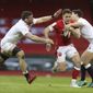 Wales&#39; Kieran Hardy, centre, is tackled by England&#39;s Mark Wilson, left and England&#39;s Ben Youngs during the Six Nations rugby union match between Wales and England at the Millennium stadium in Cardiff, Wales, Saturday, Feb. 27, 2021. (David Davies/Pool Via AP)