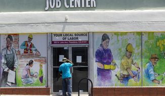 In this May 7, 2020, file photo, a person looks inside the closed doors of the Pasadena Community Job Center in Pasadena, Calif., during the coronavirus outbreak. California Gov. Gavin Newsom&#39;s administration says the massive new federal coronavirus relief bill will pump more than $150 billion into the state&#39;s economy. Nearly half of that money will go to Californians directly in the form of $1,400 stimulus checks and expanded unemployment benefits. Another $26 billion will go to the state government. Newsom will announce his plans for the money in mid-May. (AP Photo/Damian Dovarganes) **FILE**