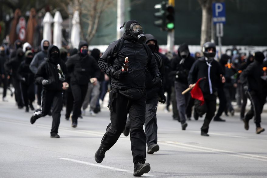 A protester holds a molotov cocktail during clashes in the northern city of Thessaloniki, Greece, Thursday, March 11, 2021. Clashes broke out between police and protesters Thursday in Greece's second-largest city, Thessaloniki, after authorities ended an occupation by students and other demonstrators at the city's main university building. (AP Photo/Giannis Papanikos)
