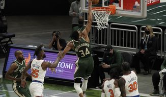 Milwaukee Bucks&#39; Giannis Antetokounmpo is fouled as he dunks during the first half of an NBA basketball game against the New York Knicks Thursday, March 11, 2021, in Milwaukee. (AP Photo/Morry Gash)