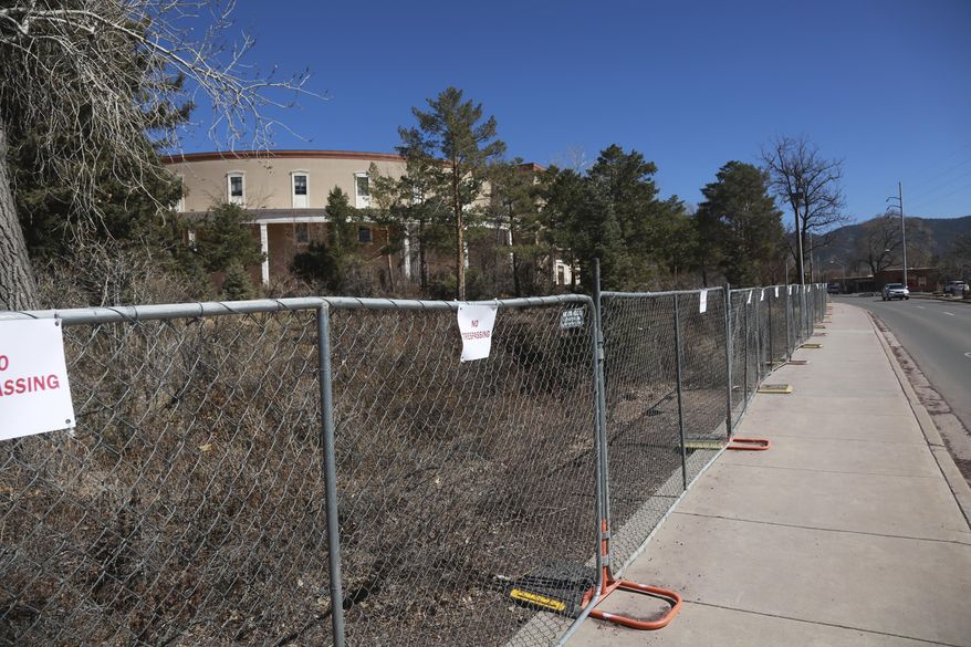 A security fence can be seen from outside the state capitol complex during a meeting of the state legislature on Thursday, March 11, 2021, in Santa Fe, New Mexico. The fence was erected as part of a series of security measures following the insurrection in the U.S. Capitol in January. State GOP leaders have asked that it be taken down. (AP Photo/Cedar Attanasio)