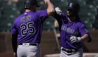 Colorado Rockies&#39; Brendan Rodgers, right, celebrates with C.J. Chron (25) after they both scored off of a home run hit by Rodgers during the first inning of a spring training baseball game against the Arizona Diamondbacks Tuesday, March 9, 2021, in Scottsdale, Ariz. (AP Photo/Ashley Landis)