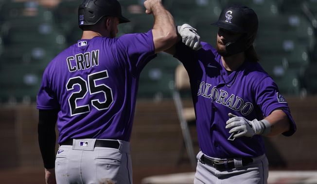 Colorado Rockies&#x27; Brendan Rodgers, right, celebrates with C.J. Chron (25) after they both scored off of a home run hit by Rodgers during the first inning of a spring training baseball game against the Arizona Diamondbacks Tuesday, March 9, 2021, in Scottsdale, Ariz. (AP Photo/Ashley Landis)