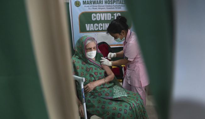 An elderly Indian woman receives COVID-19 vaccine at a private hospital in Gauhati, India, Thursday, March 11, 2021. Pandemic-weary and sequestered mostly in their homes for a year, India’s elderly are now standing in long lines at vaccination sites, then rolling up their sleeves to get shots protecting them against the coronavirus. (AP Photo/Anupam Nath)