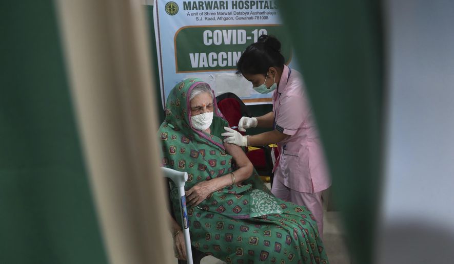 An elderly Indian woman receives COVID-19 vaccine at a private hospital in Gauhati, India, Thursday, March 11, 2021. Pandemic-weary and sequestered mostly in their homes for a year, India’s elderly are now standing in long lines at vaccination sites, then rolling up their sleeves to get shots protecting them against the coronavirus. (AP Photo/Anupam Nath)