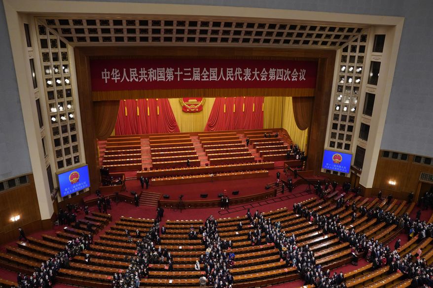 Delegates leave after the closing session of the National People's Congress in Beijing on Thursday March 11, 2021. China's ceremonial legislature on Thursday endorsed the ruling Communist Party's latest move to tighten control over Hong Kong by reducing the role of its public in picking the territory's leaders. (AP Photo/Sam McNeil)