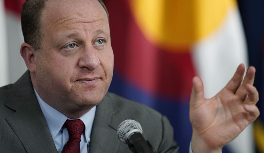 Colorado Governor Jared Polis makes a point during an update on the state&#39;s efforts to vaccinate residents against the coronavirus during a news conference Tuesday, March 9, 2021, in Denver. (AP Photo/David Zalubowski)