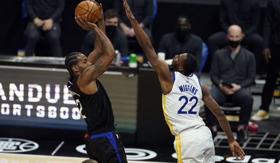 Los Angeles Clippers forward Kawhi Leonard, left, shoots over Golden State Warriors forward Andrew Wiggins (22) during the second half of an NBA basketball game Thursday, March 11, 2021, in Los Angeles. (AP Photo/Marcio Jose Sanchez)