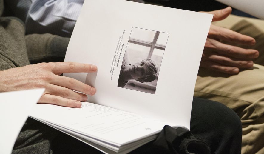 FILE - In this Oct. 26, 2018 file photo mourners hold programs with the image of Matthew Shepard during a "Thanksgiving and Remembrance of Matthew Shepard" service at Washington National Cathedral in Washington. Wyoming lawmakers have again decided not to adopt a hate crimes law in the state where gay college student Matthew Shepard was killed more than 20 years ago. Wyoming is one of just three states that haven't enacted hate crimes legislation since Shepard was beaten and left for dead in Laramie in 1998. (AP Photo/Carolyn Kaster, File)