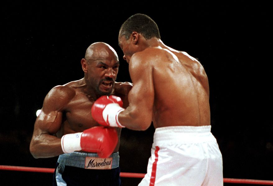 FILE - In this April 1987 file photo, &quot;Marvelous&quot; Marvin Hagler, left, moves in on &quot;Sugar&quot; Ray Leonard during the third round of a boxing bout in Las Vegas. Leonard won with a split decision. Hagler, the middleweight boxing great whose title reign and career ended with the loss to Leonard in 1987, died Saturday, March 13, 2021. He was 66. (AP Photo/Lennox McLendon, File)