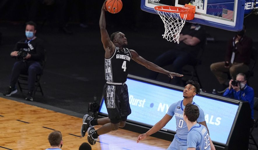 Georgetown&#x27;s Chudier Bile (4) dunks the ball in front of Creighton&#x27;s Ryan Kalkbrenner (32) and Antwann Jones (0) during the second half of an NCAA college basketball game in the championship of the Big East Conference tournament Saturday, March 13, 2021, in New York. (AP Photo/Frank Franklin II)