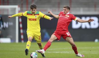 Union&#39;s Grischa Proemel, right, and Cologne&#39;s Elvis Rexhbecaj, left, challenge for the ball during the German Bundesliga soccer match between 1. FC Union Berlin and 1. FC Cologne in Berlin, Germany, Saturday, March 13, 2021. (Andreas Gora/dpa via AP)
