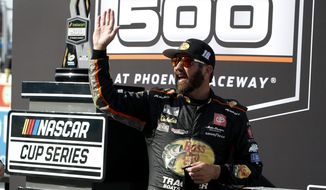 Martin Truex Jr waves to fans from Victory Lane after winning a NASCAR Cup Series auto race at Phoenix Raceway, Sunday, March 14, 2021, in Avondale, Ariz. (AP Photo/Ralph Freso)