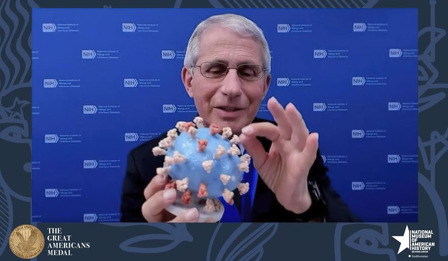 This image from video provided by Smithsonian&#39;s National Museum of American History shows Dr. Anthony Fauci, director of the National Institute of Allergy and Infectious Diseases and chief medical adviser to the president, holding his personal 3D model of the COVID-19 virus he is donating to the Smithsonian’s National Museum of American History on Tuesday, March 2, 2020. Fauci presented the donation Tuesday night in a virtual ceremony to honor him with the museum’s Great Americans Medal. (Smithsonian&#39;s National Museum of American History via AP)