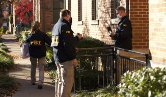 FILE-This Nov. 16, 2020 file photo shows FBI agents removing items from the home of then Public Utilities Commission of Ohio Chairman Sam Randazzo in Columbus, Ohio. State and federal officials are investigating whether Randazzo, the utility lawyer-turned-regulator who has since resigned, helped usher through a string of legislative and regulatory victories worth well over $1 billion over time to energy giant FirstEnergy Corp. and its subsidiaries, in exchange for cash. (Adam Cairns/The Columbus Dispatch via AP)