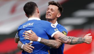 Brighton&#x27;s Lewis Dunk, left and Ben White celebrate at the end of an English Premier League soccer match between Southampton and Brighton after defeating Southampton at the St Mary&#x27;s Stadium in Southampton, England, Sunday March 14, 2021. (Andrew Couldridge/Pool via AP)