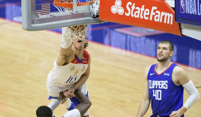 New Orleans Pelicans center Jaxson Hayes (10) dunks against Los Angeles Clippers guard Reggie Jackson (1) in the second half of an NBA basketball game in New Orleans, Sunday, March 14, 2021. (AP Photo/Matthew Hinton)
