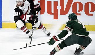 Arizona Coyotes&#39; Phil Kessel (81) has the puck against Minnesota Wild&#39;s Nico Sturm (7), of Germany, during the first period of an NHL hockey game Sunday, March 14, 2021, in St. Paul, Minn. (AP Photo/Hannah Foslien)