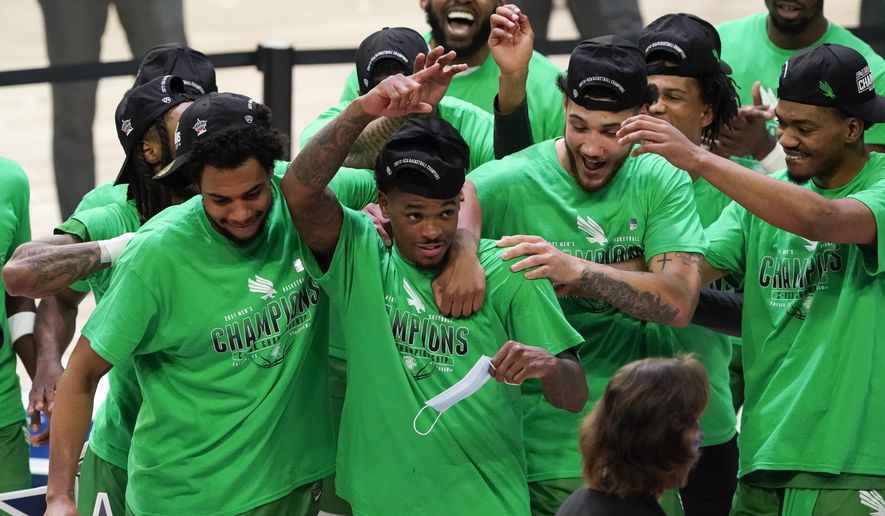 North Texas guard Javion Hamlet, center, celebrates with teammates after the championship game against Western Kentucky in the NCAA Conference USA men's basketball tournament Saturday, March 13, 2021, in Frisco, Texas. North Texas won 61-57 in overtime. (AP Photo/Tony Gutierrez)
