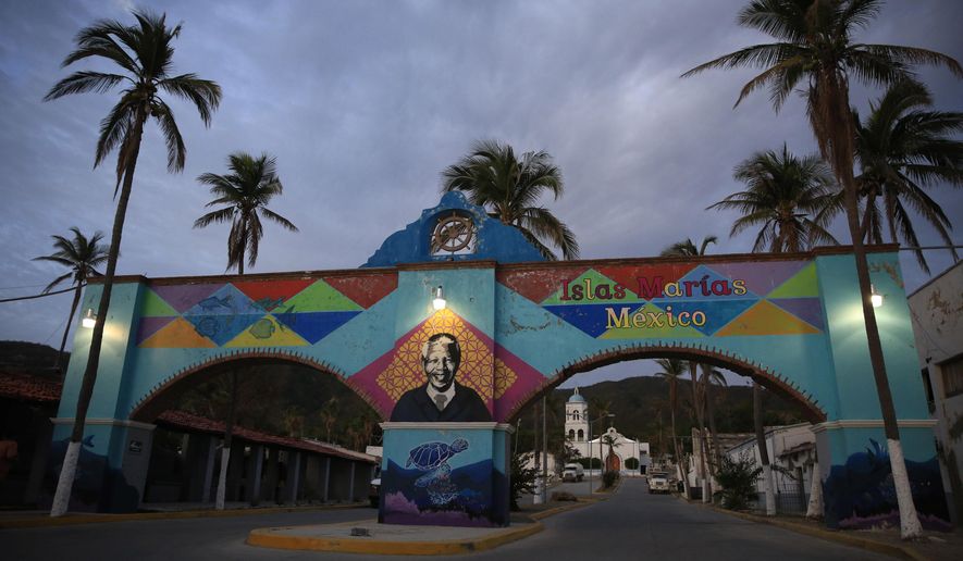 FILE - In this March 17, 2019 file photo, a mural of Nelson Mandela, who spent many of his imprisoned years in an island prison in South Africa, adorns a gate in front of the dock where prison staff and inmates arrive in Navy boats to the now closed Islas Maria penal colony located off Mexico's Pacific coast. Mexican officials said on Saturday, March 13, 2021, that ferries and cruise ships may soon be visiting the former prison, after the last island penal colony in the Americas was closed and turned into an environmental education center in 2019. (AP Photo/Rebecca Blackwell, File)