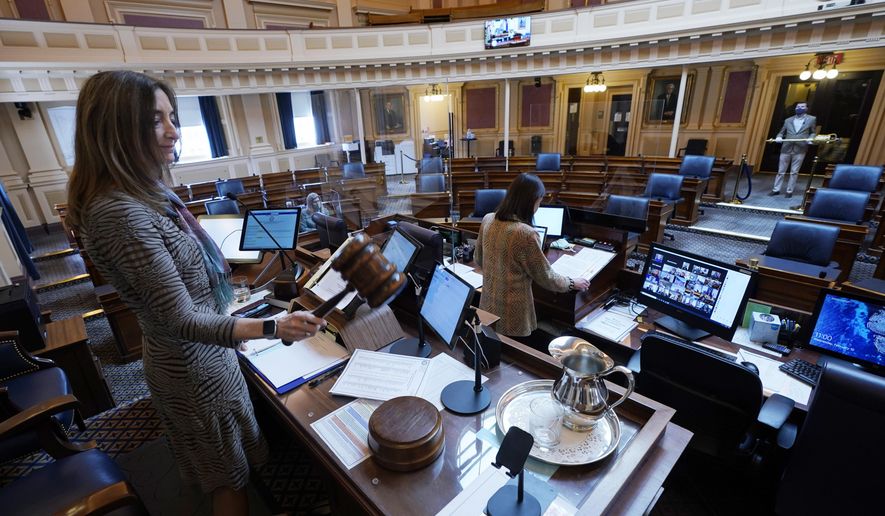 FILE - In this Feb. 10, 2021, file photo, House speaker Del. Eileen Filler-Corn, D-Fairfax, gavels in the session to an empty Virginia House of Delegates chamber after a Zoom Legislative session at the Capitol in Richmond, Va. A year after COVID-19 triggered government shutdowns and crowd limitations, more public bodies than ever are livestreaming their meetings for anyone to watch from a computer, television or smartphone. But in some cases, it's become harder for people to actually talk with their elected officials. (AP Photo/Steve Helber, File)