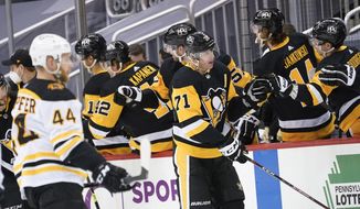 Pittsburgh Penguins Evgeni Malkin (71) celebrates with teammates on the bench after scoring as Boston Bruins&#39; Steve Kampfer (44) skates by during the second period of an NHL hockey game, Monday, March 15, 2021, in Pittsburgh. (AP Photo/Keith Srakocic)
