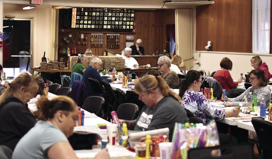 People play bingo at the Danish Brotherhood in Ludington, Mich., on March 4, 2021. Once upon a time, there was somewhere people could go to play bingo every night of the week in Mason County, but now, the Danish Hall in Ludington's Fourth Ward is the only one that remains. Every Thursday, the doors open at 4:30 p.m. and players get their bingo cards, set up their tables and get ready to win some money. (Hannah Hubbard/Ludington Daily News via AP)