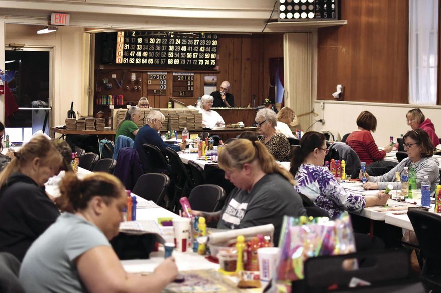 People play bingo at the Danish Brotherhood in Ludington, Mich., on March 4, 2021. Once upon a time, there was somewhere people could go to play bingo every night of the week in Mason County, but now, the Danish Hall in Ludington's Fourth Ward is the only one that remains. Every Thursday, the doors open at 4:30 p.m. and players get their bingo cards, set up their tables and get ready to win some money. (Hannah Hubbard/Ludington Daily News via AP)