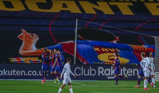 Barcelona&#39;s Oscar Mingueza, center left, celebrates after scoring his side&#39;s third goal during the Spanish La Liga soccer match between FC Barcelona and Huesca at the Camp Nou stadium in Barcelona, Spain, Monday, March 15, 2021. (AP Photo/Joan Monfort)
