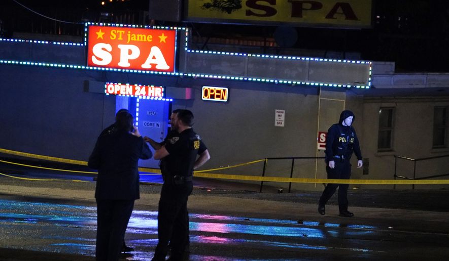 Law enforcement officials confer outside a massage parlor following a shooting on Tuesday, March 16, 2021, in Atlanta. Shootings at two massage parlors in Atlanta and one in the suburbs have left seven people dead, many of them women of Asian descent, authorities said Tuesday. (AP Photo/Brynn Anderson)