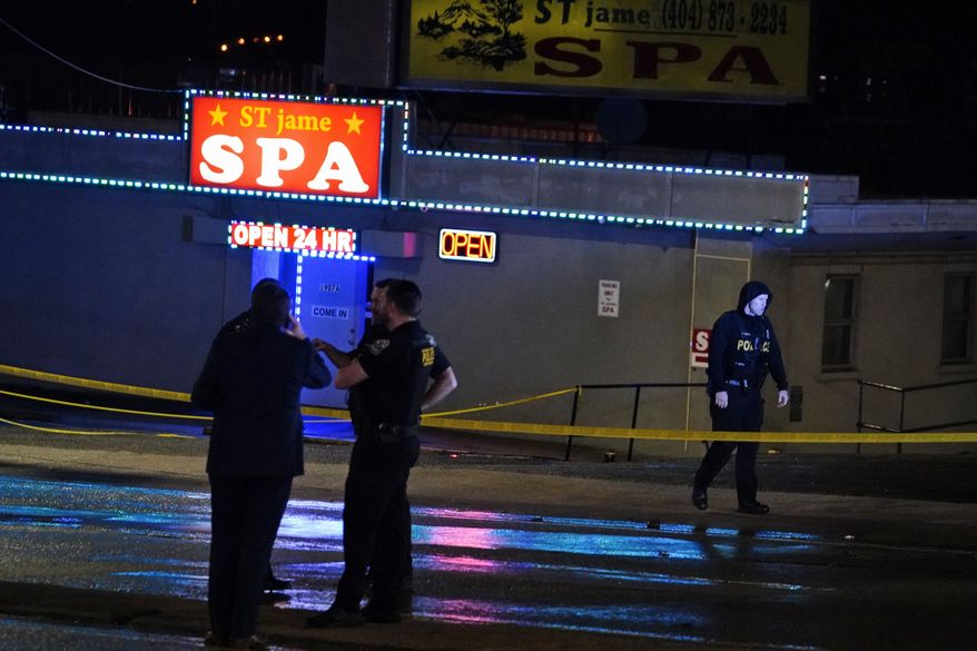 Law enforcement officials confer outside a massage parlor following a shooting on Tuesday, March 16, 2021, in Atlanta. Shootings at two massage parlors in Atlanta and one in the suburbs have left seven people dead, many of them women of Asian descent, authorities said Tuesday. (AP Photo/Brynn Anderson)