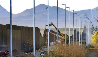 In this Dec. 8, 2020, file photo, crews construct a section of border wall in San Bernardino National Wildlife Refuge in Douglas, Ariz. (AP Photo/Matt York, File)