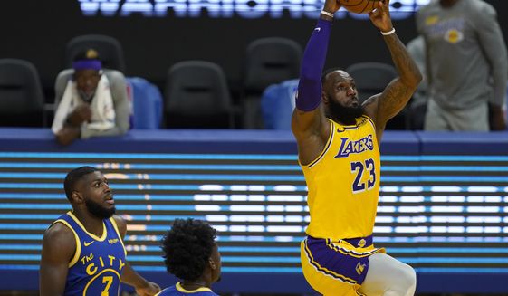 Los Angeles Lakers forward LeBron James (23) dunks in front of Golden State Warriors forward Eric Paschall (7) and center James Wiseman during the first half of an NBA basketball game in San Francisco, Monday, March 15, 2021. (AP Photo/Jeff Chiu)