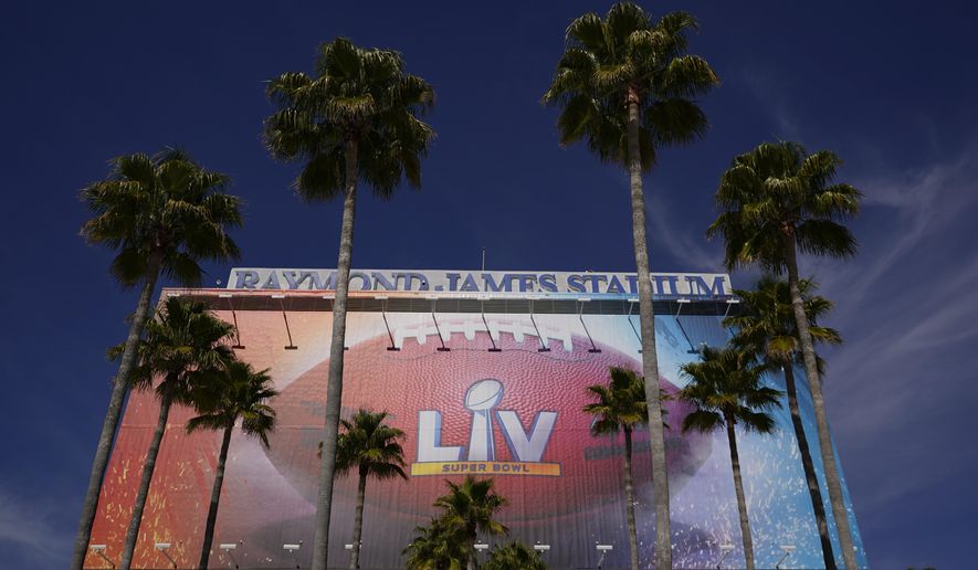 FILE - In this Feb. 4, 2021 file photo A sign for Super Bowl 55 is framed by palm trees at Raymond James Stadium in Tampa, Fla. Despite the Super Bowl, New Jersey’s casinos and racetracks took in $200 million less in sports bets in February than they did a month earlier. Figures released Tuesday, March 16, by state regulators show the gambling outlets handled nearly $743 million worth of sports bets in February. (AP Photo/Charlie Riedel, File)