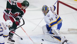 Buffalo Sabres goaltender Jonas Johansson (34) stops a shot on goal by New Jersey Devils&#39; Miles Wood (44) during the second period of an NHL hockey game Tuesday, March 16, 2021, in Newark, N.J. (AP Photo/Frank Franklin II)