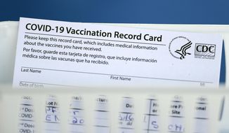 A vaccination record card is shown during a COVID-19 vaccination drive for Spring Branch Independent School District education workers Tuesday, March 16, 2021, in Houston. School employees who registered were given the Pfizer vaccine.(AP Photo/David J. Phillip)