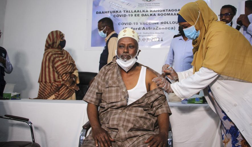 Dr. Maxamed Maxamuud Fuje receives a shot of AstraZeneca COVID-19 vaccine, manufactured by the Serum Institute of India and provided through the global COVAX initiative, at a ceremony to mark the start of coronavirus vaccinations in Mogadishu, Somalia Tuesday, March 16, 2021. (AP Photo/Farah Abdi Warsameh)