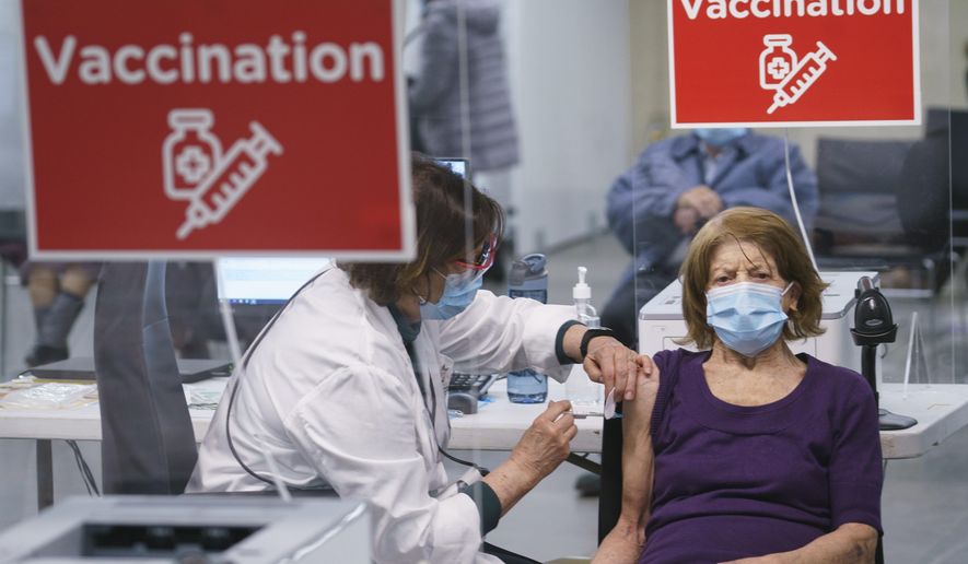 In this March 1, 2021, file photo, a woman receives her COVID-19 vaccine at a clinic marking the beginning of mass vaccination in the Province of Quebec based on age in Montreal. Canada once was hailed as a success story in dealing with the coronavirus pandemic, faring much better than the United States in deaths and infections because of how it approached lockdowns. But the trade-dependent nation has lagged on vaccinating its population because it has had to rely on the global supply chain. (Paul Chiasson/The Canadian Press via AP, File)