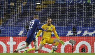 Atletico Madrid&#39;s goalkeeper Jan Oblak, right, fails to save the ball as Chelsea&#39;s Hakim Ziyech scores his side&#39;s opening goal during the Champions League, round of 16, second leg soccer match between Chelsea and Atletico Madrid at the Stamford Bridge stadium, London, Wednesday, March 17, 2021. (AP Photo/Matt Dunham)