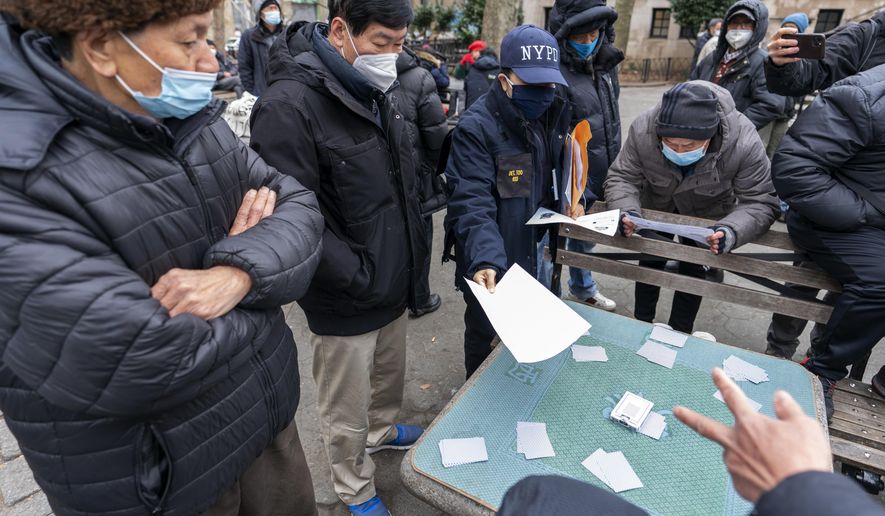 Detective Suk H Too, second from right, with the New York Police Department Community Affairs Rapid Response Unit hands out fliers with information on how to report hate crimes to residents while on a community outreach patrol in the Chinatown neighborhood of New York, Wednesday, March 17, 2021. New York City is deploying additional law enforcement personnel to Asian communities in the wake of a series of shootings at three Atlanta area massage parlors. (AP Photo/Mary Altaffer)