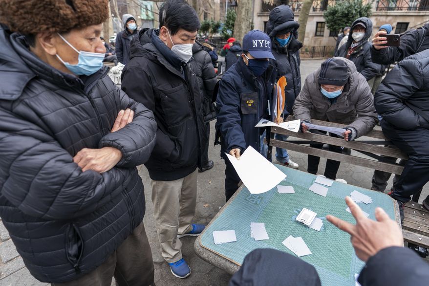 Detective Suk H Too, second from right, with the New York Police Department Community Affairs Rapid Response Unit hands out fliers with information on how to report hate crimes to residents while on a community outreach patrol in the Chinatown neighborhood of New York, Wednesday, March 17, 2021. New York City is deploying additional law enforcement personnel to Asian communities in the wake of a series of shootings at three Atlanta area massage parlors. (AP Photo/Mary Altaffer)