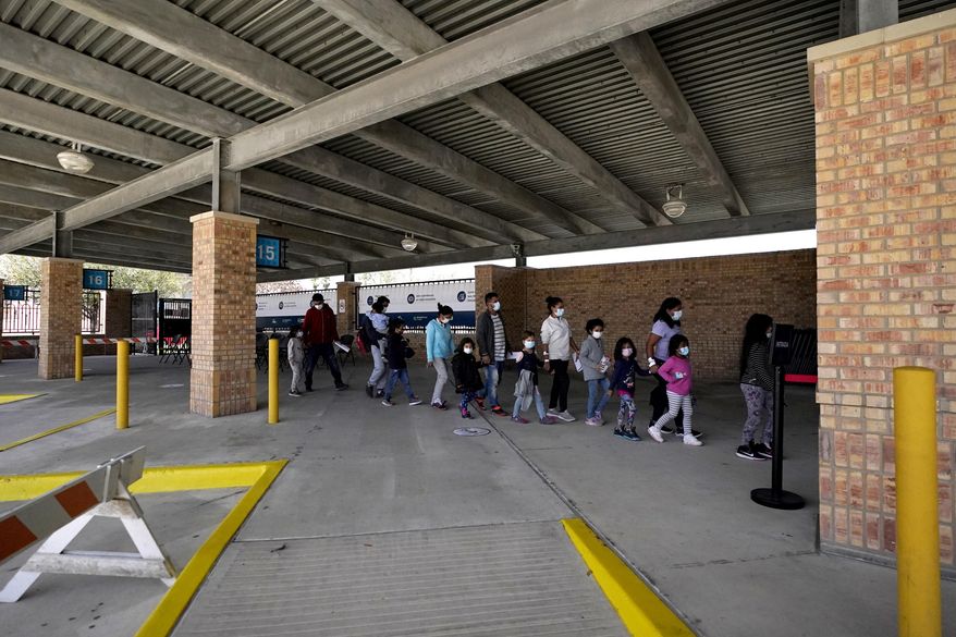 Migrants stand in line after being released from U.S. Customs and Border Protection custody at a bus station, Wednesday, March 17, 2021, in Brownsville, Texas. Team Brownsville, a humanitarian group, is helping the migrants reach their final destination in the U.S. A surge of migrants on the Southwest border has the Biden administration on the defensive. An official says U.S. authorities encountered nearly double the number children traveling alone across the Mexican border in one day this week than on an average day last month. (AP Photo/Julio Cortez)